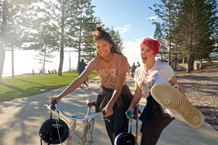 Girls with bikes on footpath