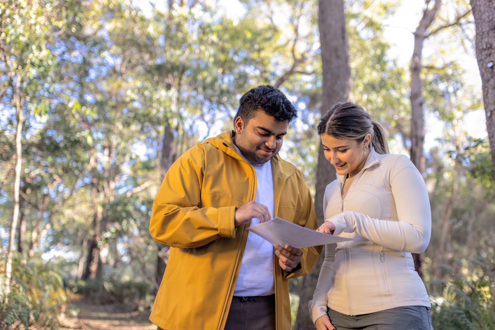 Two young people look at a map as they explore West Australian bushland