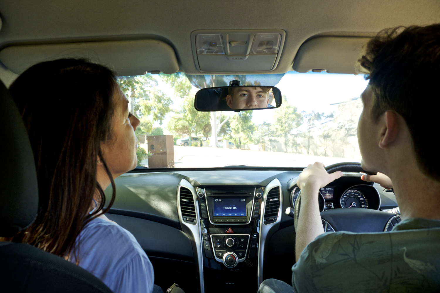 Parent teaching teen to reverse car 