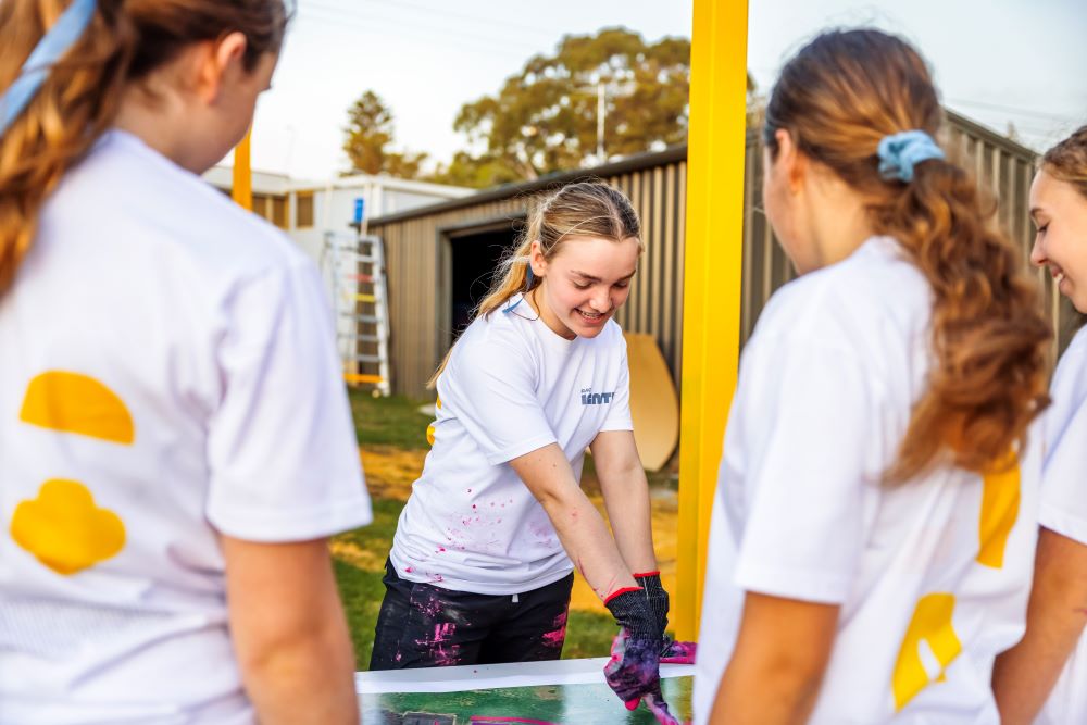 A group of young volunteers build outdoor furniture for the Mosman Park Better Blocks makeover project