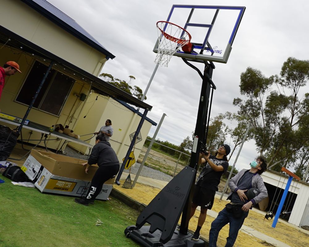 Young volunteers working to set-up the new basketball hoop
